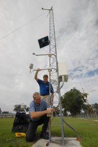 Rick Lusher, standing, and George Braun, field site supervisor for FAWN, install a temperature sensor at a monitoring station located at UF's Plant Science Research and Education Unit in Citra, Fla. Spring 2008 Impact Magazine image. UF/IFAS File Photo.