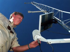 Larry Treadaway, coordinator of the Florida Automated Weather Network, adjusts equipment at a new monitoring station in Bronson, Fla. The Levy County site, provided by UF's Department of Astronomy, is one of 13 new stations added to the network during the past year to improve statewide coverage. The network, which now includes 33 monitoring stations operated by UF's Institute of Food and Agricultural Sciences, transmits real-time weather data to computers in Gainesville. Growers and others can access the data via phone or the FAWN Web site: http://fawn.ifas.ufl.edu.